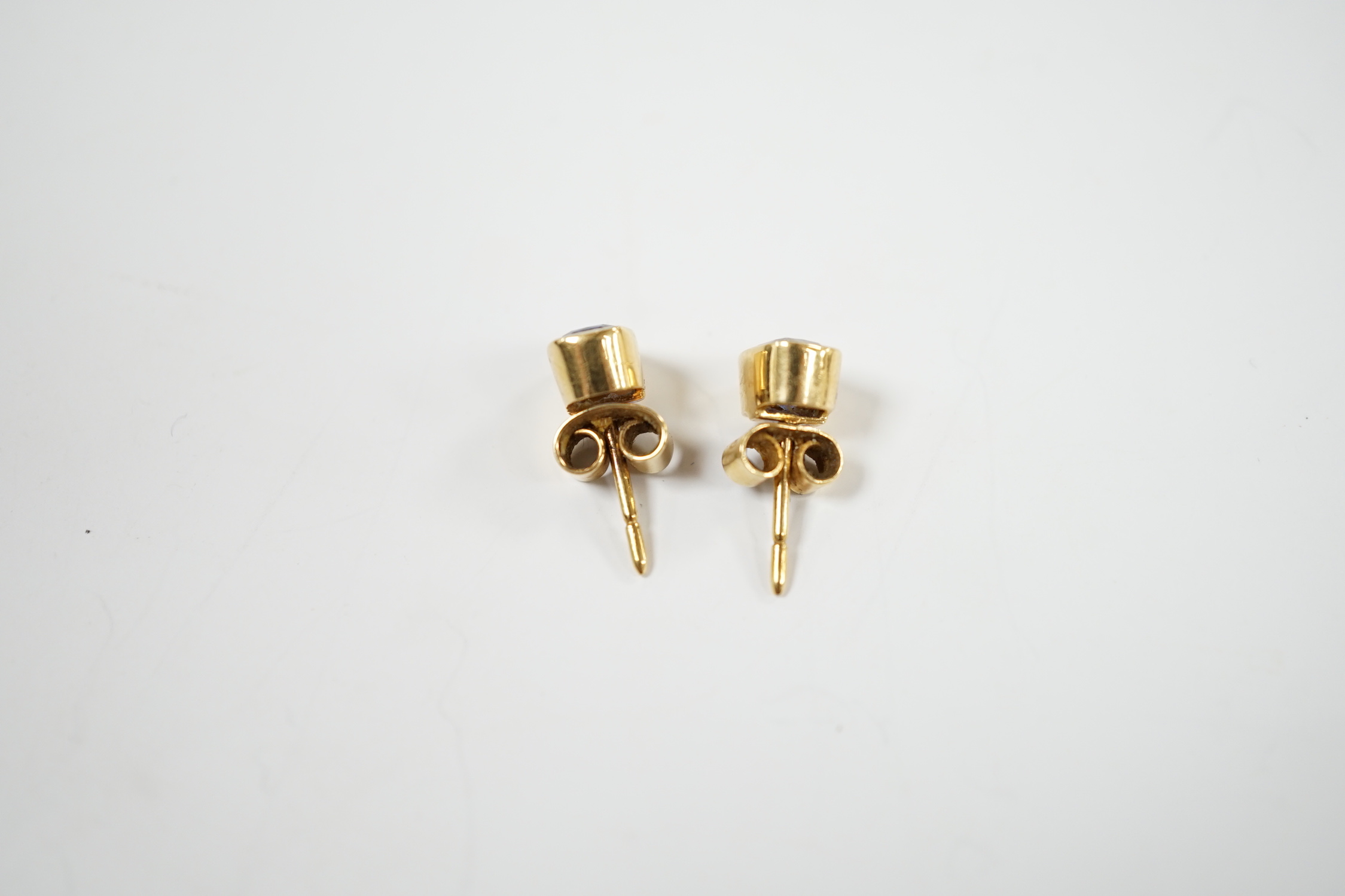 A pair of 750 yellow metal and single stone Ceylon sapphire set ear studs, 7mm, gross weight 2.9 grams.